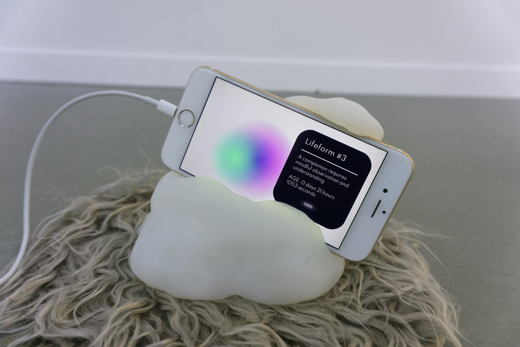 A smartphone showing a colorful orb rests in a blobby white resin