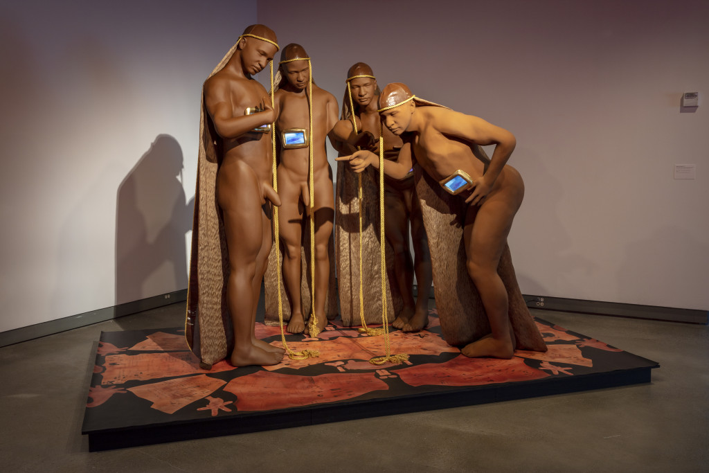 A sculptural composition of four figures, some with small video screens embedded in their bodies