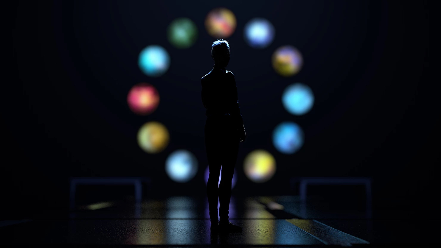A silhouetted figure seen from behind stands before a circle of multicolored glowing orbs
