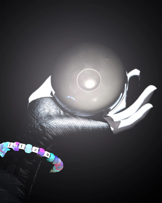 A hand holds a glowing gray orb. A beaded bracelet with letters spelling EXIT is worn on the wrist