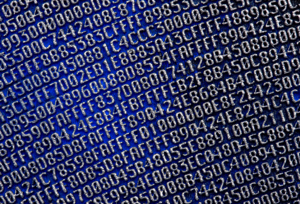 A close-up photograph of silver numbers and letters embossed on a blue background