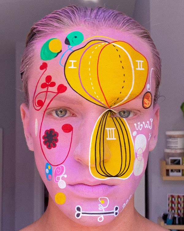 A selfie-style photograph of a person with colorful face paint that resembles the artwork of Hilma af Klint