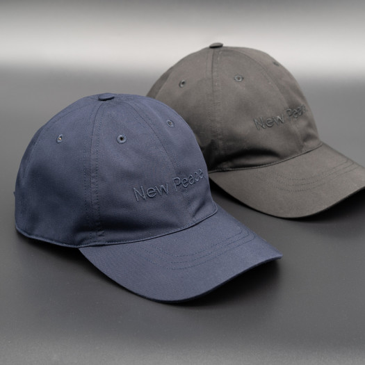 A pair of hats, one blue and one gray, with the words New Peace embroidered in the same color as the fabric