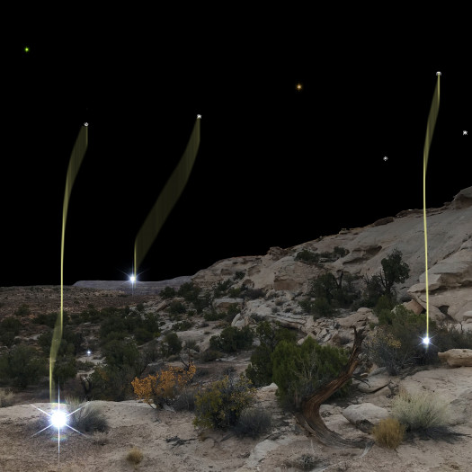 A digital image of moving points of light in a desert landscape at night