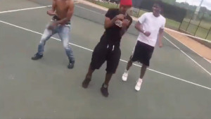 An image of three young men on a tennis court; the image is tilted an grainy, as if taken from low-quality cell phone footage