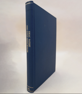 A photograph of a book bound in blue leather, standing at an angle against a white background