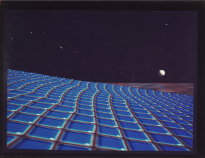 A lo-fi computer-generated image of an extra-terrestrial scene, with a bright blue terrain and a moon peeking over the horizon