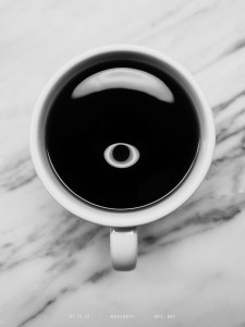 A cup of coffee on a marble counter, photographed in black-and-white from above