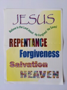A photograph of a religious pamphlet, the cover of which has text in a number of colors and fonts