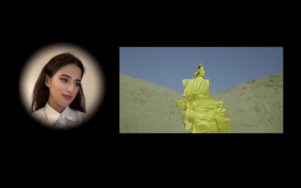 Against a black background, two video channels show a woman's face in a hazy cameo gazing kindly upon a horizontal screen showing a man in a flowing yellow robe in the desert
